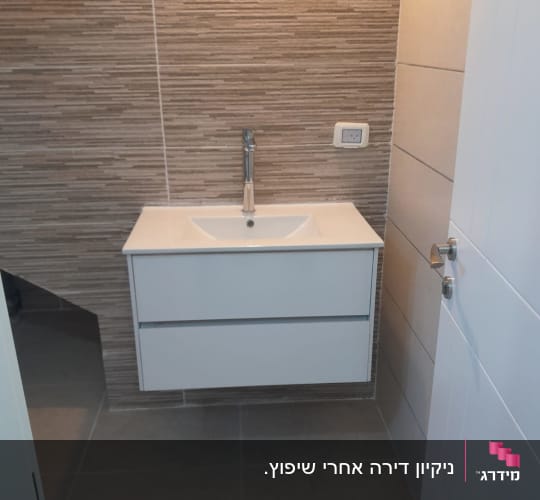כיור לבן עם ברז בחדר אמבטיה